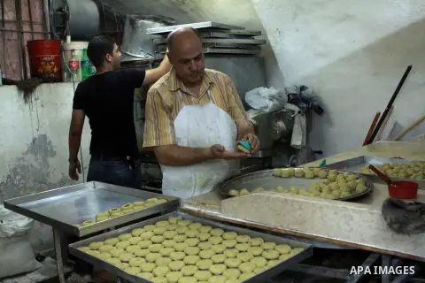 A Palestinian worker makes traditional date-filled cookies in preparation for the of Eid al-Adha, in the West Bank city of Nablus, on October 23, 2012. Muslims around the world prepare to celebrate Eid Al-Adha, which acc...