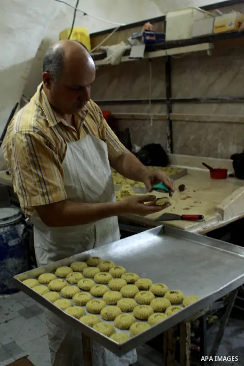 A Palestinian worker makes traditional date-filled cookies in preparation for the of Eid al-Adha, in the West Bank city of Nablus, on October 23, 2012. Muslims around the world prepare to celebrate Eid Al-Adha, which acc...