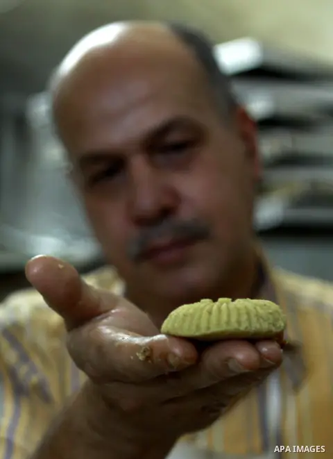 A Palestinian worker makes traditional date-filled cookies in preparation for the of Eid al-Adha, in the West Bank city of Nablus, on October 23, 2012. Muslims around the world prepare to celebrate Eid Al-Adha, which acc...