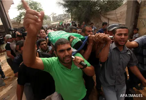 Palestinian mourners carry the body of Hamas militant Ismail al-Tili during his funeral in Beit Lahia, northern Gaza Strip, on October 24, 2012. Palestinians fired more than 40 rockets from the Gaza Strip into Israel inj...