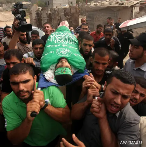Palestinian mourners carry the body of Hamas militant Ismail al-Tili during his funeral in Beit Lahia, northern Gaza Strip, on October 24, 2012. Palestinians fired more than 40 rockets from the Gaza Strip into Israel inj...