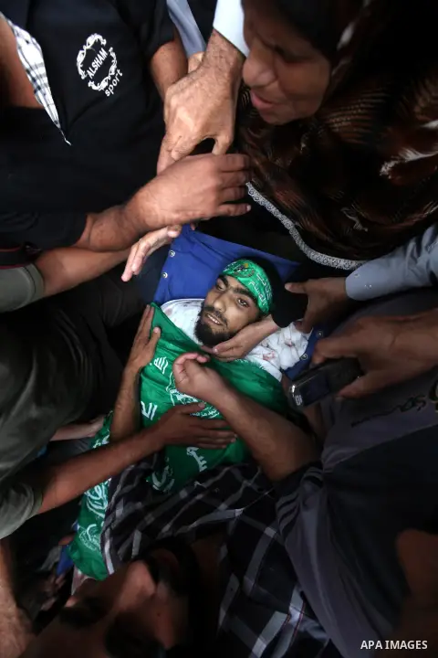 Palestinian mourners carry the body of Hamas militant Ismail al-Tili during his funeral in Beit Lahia, northern Gaza Strip, on October 24, 2012. Palestinians fired more than 40 rockets from the Gaza Strip into Israel inj...