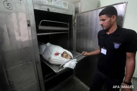 A Palestinian morgue worker shows the body of Palestinian Hamas militant Louai Abu Jarad is seen at the morgue of a hospital in Beit Lahia, northern Gaza Strip, on October 24, 2012. Palestinians fired more than 40 rocket...