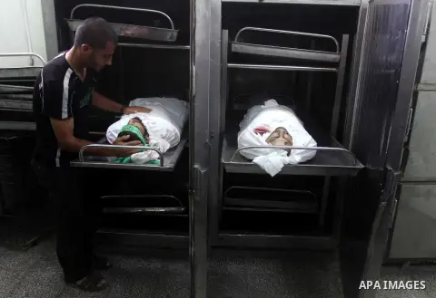 A Palestinian morgue worker shows the body of Palestinian Hamas militant Louai Abu Jarad is seen at the morgue of a hospital in Beit Lahia, northern Gaza Strip, on October 24, 2012. Palestinians fired more than 40 rocket...