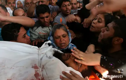 The mother of Palestinian militant Mohamed al-Shikh mourns over his body during his funeral in Rafah, southern Gaza Strip, on October 24, 2012. Palestinians fired more than 40 rockets from the Gaza Strip into Israel inju...