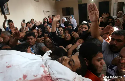 Palestinian mourners carry the body of militant Mohamed al-Shikh during his funeral in Rafah, southern Gaza Strip, on October 24, 2012. Palestinians fired more than 40 rockets from the Gaza Strip into Israel injuring thr...
