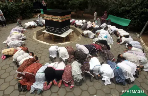Palestinian children gather around a makeshift cube representing the holy Kaaba in Gaza City, on October 24, 2012, as part of training children how to perform Hajj pilgrimage. Muslims from around the world flood Saudi ci...