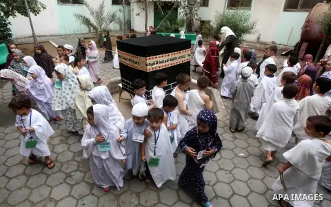 Palestinian children gather around a makeshift cube representing the holy Kaaba in Gaza City, on October 24, 2012, as part of training children how to perform Hajj pilgrimage. Muslims from around the world flood Saudi ci...