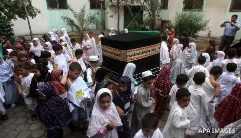 Palestinian children gather around a makeshift cube representing the holy Kaaba in Gaza City, on October 24, 2012, as part of training children how to perform Hajj pilgrimage. Muslims from around the world flood Saudi ci...