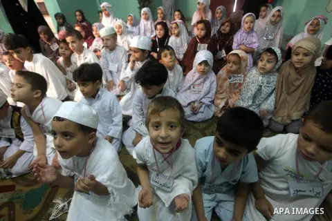 Palestinian children gather around a makeshift cube representing the holy Kaaba in Gaza City, on October 24, 2012, as part of training children how to perform Hajj pilgrimage. Muslims from around the world flood Saudi ci...