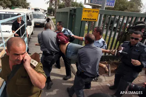 A Palestinian activist is arrested by Israeli soldiers as dozens of Palestinians block the entrance to branch of the Rami Levy supermarket opened in Shaar Binyamin close to the city of Ramallah in the Israeli occupied Pa...