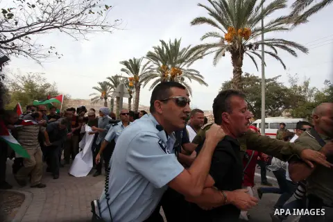 A Palestinian activist is arrested by Israeli soldiers as dozens of Palestinians block the entrance to branch of the Rami Levy supermarket opened in Shaar Binyamin close to the city of Ramallah in the Israeli occupied Pa...