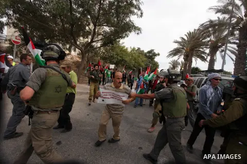 Palestinian, Israeli and foreign activists scuffle with Israeli troops after storming a supermarket in protest against Jewish settlements in a call on Palestinian shoppers to boycott settlement products and businesses in...