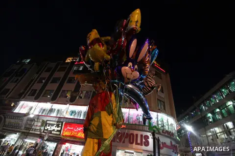 A Palestinian man sells ballons during preparations for the Eid al-Adha, in the West Bank city of Ramallah, on October 24, 2012. Muslims around the world prepare to celebrate Eid Al-Adha, which according to the lunar cal...