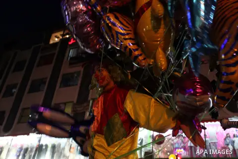 A Palestinian man sells ballons during preparations for the Eid al-Adha, in the West Bank city of Ramallah, on October 24, 2012. Muslims around the world prepare to celebrate Eid Al-Adha, which according to the lunar cal...