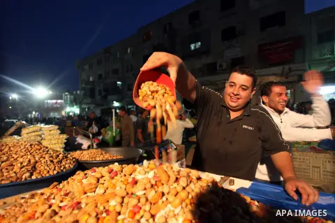 A Palestinian man sells nuts during preparations for the Eid al-Adha, in the West Bank city of Ramallah, on October 24, 2012. Muslims around the world prepare to celebrate Eid Al-Adha, which according to the lunar calend...