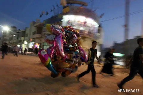 A Palestinian man sells ballons during preparations for the Eid al-Adha, in the West Bank city of Ramallah, on October 24, 2012. Muslims around the world prepare to celebrate Eid Al-Adha, which according to the lunar cal...
