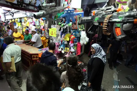 Palestinians shop at a market during preparations for the Eid al-Adha, in the West Bank city of Ramallah, on October 24, 2012. Muslims around the world prepare to celebrate Eid Al-Adha, which according to the lunar calen...