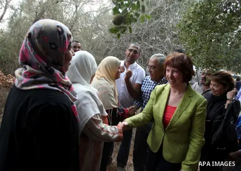 Palestinian Prime Minister Salam Fayyad and EU Foreign Policy chief Catherine Ashton help Palestinian farmers during harvesting olives in the West Bank village of Ras Karkar near Ramallah, on October 25, 2012. Photo by I...