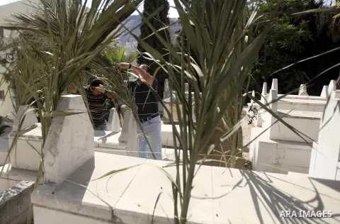 Palestinians put palm fronds on the graves of their relatives ahead of Muslim festival of Eid al-Adha, in the West Bank city of Nablus, on October 25, 2012. Muslims around the world prepare to celebrate Eid Al-Adha, whic...