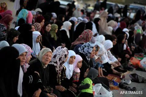 Palestinians listen to a speech by Palestinian Prime Minister in gaza, Ismail Haniya during a mass prayer on the first day of the Muslim holiday of Eid al-Adha, at al-Nusairat, in the central Gaza Strip, on October 26, 2...