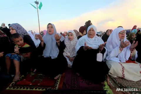 Palestinians listen to a speech by Palestinian Prime Minister in gaza, Ismail Haniya during a mass prayer on the first day of the Muslim holiday of Eid al-Adha, at al-Nusairat, in the central Gaza Strip, on October 26, 2...