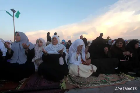 Palestinians listen to a speech by Palestinian Prime Minister in gaza, Ismail Haniya during a mass prayer on the first day of the Muslim holiday of Eid al-Adha, at al-Nusairat, in the central Gaza Strip, on October 26, 2...