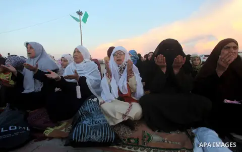 Palestinians listen to a speech by Palestinian Prime Minister in gaza, Ismail Haniya during a mass prayer on the first day of the Muslim holiday of Eid al-Adha, at al-Nusairat, in the central Gaza Strip, on October 26, 2...