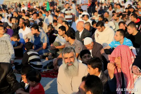 Palestinians listen to a speech by Palestinian Prime Minister in gaza, Ismail Haniya during a mass prayer on the first day of the Muslim holiday of Eid al-Adha, at al-Nusairat, in the central Gaza Strip, on October 26, 2...