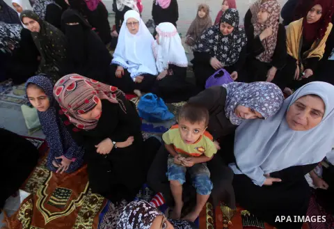 Palestinians listen to a speech by Palestinian Prime Minister in gaza, Ismail Haniya during a mass prayer on the first day of the Muslim holiday of Eid al-Adha, at al-Nusairat, in the central Gaza Strip, on October 26, 2...