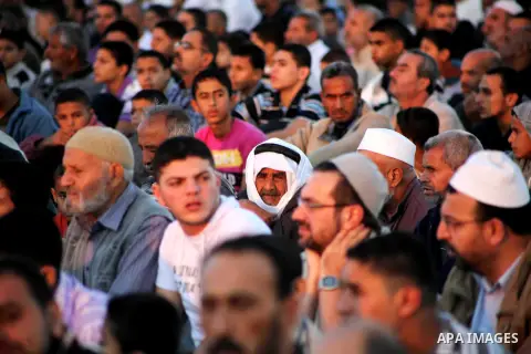 Palestinians listen to a speech by Palestinian Prime Minister in gaza, Ismail Haniya during a mass prayer on the first day of the Muslim holiday of Eid al-Adha, at al-Nusairat, in the central Gaza Strip, on October 26, 2...