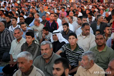 Palestinians listen to a speech by Palestinian Prime Minister in gaza, Ismail Haniya during a mass prayer on the first day of the Muslim holiday of Eid al-Adha, at al-Nusairat, in the central Gaza Strip, on October 26, 2...