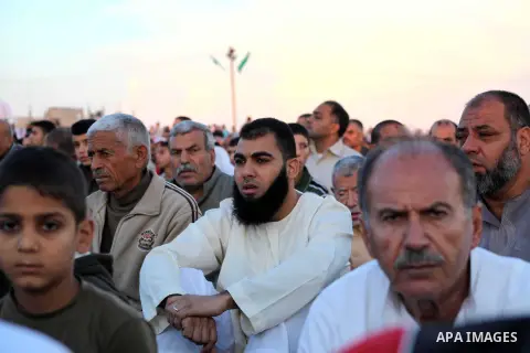 Palestinians listen to a speech by Palestinian Prime Minister in gaza, Ismail Haniya during a mass prayer on the first day of the Muslim holiday of Eid al-Adha, at al-Nusairat, in the central Gaza Strip, on October 26, 2...