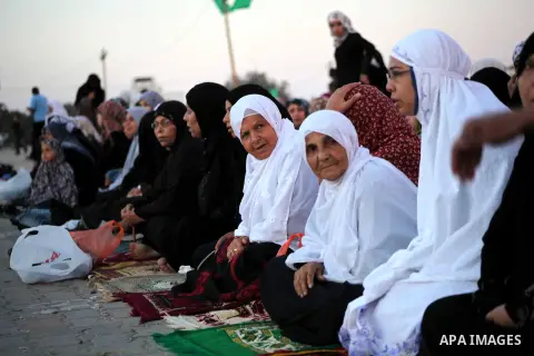 Palestinians listen to a speech by Palestinian Prime Minister in gaza, Ismail Haniya during a mass prayer on the first day of the Muslim holiday of Eid al-Adha, at al-Nusairat, in the central Gaza Strip, on October 26, 2...