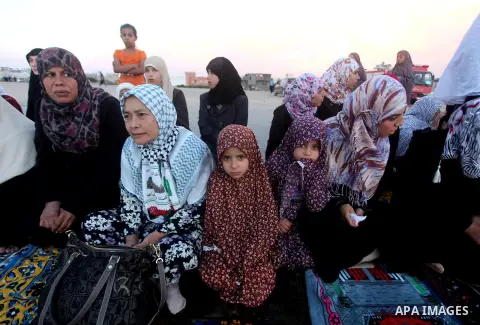 Palestinians listen to a speech by Palestinian Prime Minister in gaza, Ismail Haniya during a mass prayer on the first day of the Muslim holiday of Eid al-Adha, at al-Nusairat, in the central Gaza Strip, on October 26, 2...