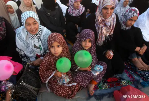 Palestinians listen to a speech by Palestinian Prime Minister in gaza, Ismail Haniya during a mass prayer on the first day of the Muslim holiday of Eid al-Adha, at al-Nusairat, in the central Gaza Strip, on October 26, 2...