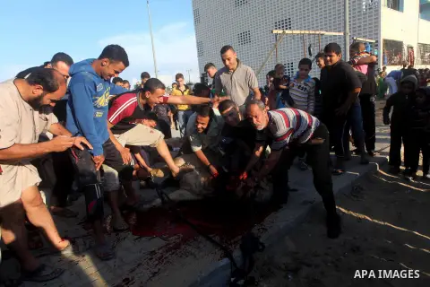 Palestinians watch as a butcher slaughters a bull on the first day of Eid al-Adha at Khan Younis in the southern Gaza Strip October 26, 2012. Muslims around the world celebrate Eid-al-Adha, marking the end of the haj, by...