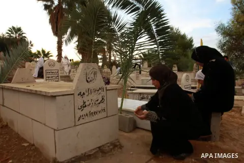 Palestinians visit the graves of relatives at a cemetery in the West Bank city of Nablus on the first day of Eid al-Adha, on October 26, 2012 as Muslims worldwide commemorate Eid al-Adha, or the Feast of the Sacrifice, m...