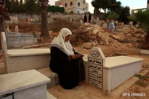 Palestinians visit the graves of relatives at a cemetery in the West Bank city of Nablus on the first day of Eid al-Adha, on October 26, 2012 as Muslims worldwide commemorate Eid al-Adha, or the Feast of the Sacrifice, m...