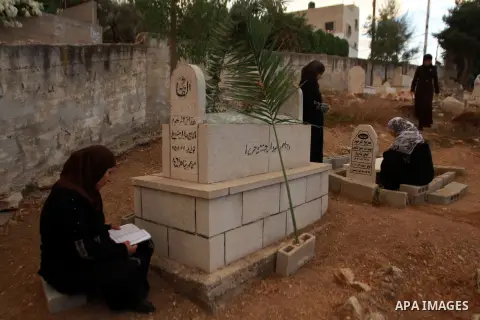 Palestinians visit the graves of relatives at a cemetery in the West Bank city of Nablus on the first day of Eid al-Adha, on October 26, 2012 as Muslims worldwide commemorate Eid al-Adha, or the Feast of the Sacrifice, m...