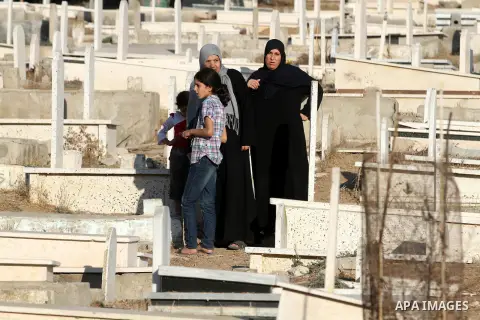 Palestinians visit the graves of relatives at a cemetery in Gaza city on the first day of Eid al-Adha, on October 26, 2012 as Muslims worldwide commemorate Eid al-Adha, or the Feast of the Sacrifice, marking the end of t...