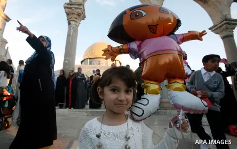 Palestinian children hold balloons in front of the Dome of the Rock in Jerusalem's Old city, on the first day of Eid al-Adha October 26, 2012. Muslims around the world celebrate Eid al-Adha to mark the end of the Haj by...