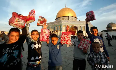 Palestinian children play in front of the Dome of the Rock in Jerusalem's Old city, on the first day of Eid al-Adha October 26, 2012. Muslims around the world celebrate Eid al-Adha to mark the end of the Haj by slaughter...