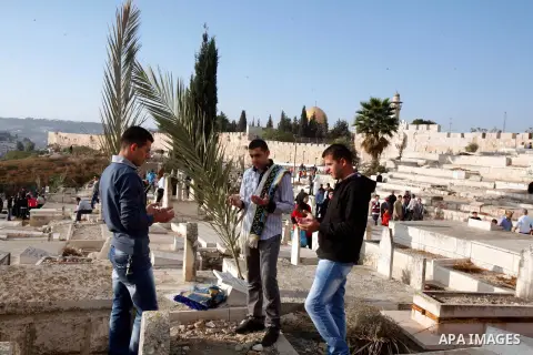 Palestinians visit the graves of relatives at a cemetery in city of jerusalem on the first day of Eid al-Adha on October 26, 2012 as Muslims worldwide commemorate Eid al-Adha, or the Feast of the Sacrifice, marking the e...