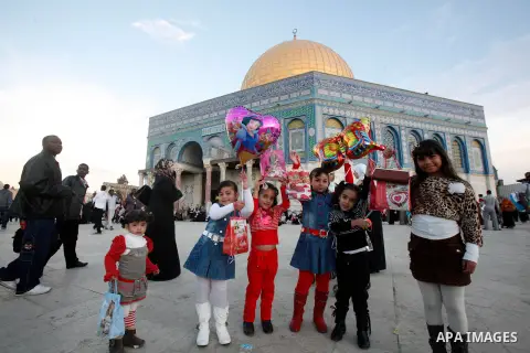 Palestinian children hold balloons in front of the Dome of the Rock in Jerusalem's Old city, on the first day of Eid al-Adha October 26, 2012. Muslims around the world celebrate Eid al-Adha to mark the end of the Haj by...