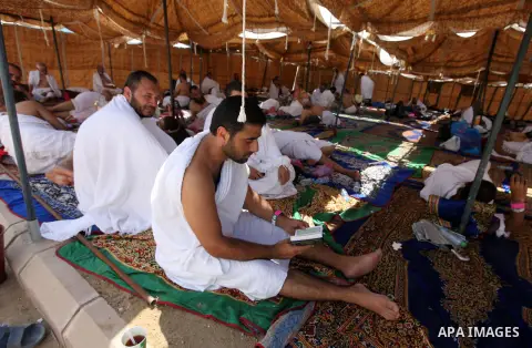 A Muslim pilgrim reads while others rests on Mount Mercy on the plains of Arafat during the peak of the annual haj pilgrimage near the holy city of Mecca October 26, 2012. Nearly 3 million Muslim pilgrims started the fir...