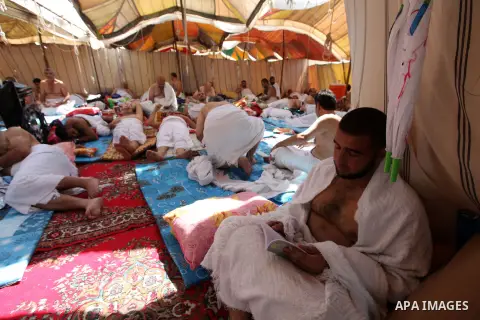 A Muslim pilgrim reads while others rests on Mount Mercy on the plains of Arafat during the peak of the annual haj pilgrimage near the holy city of Mecca October 26, 2012. Nearly 3 million Muslim pilgrims started the fir...