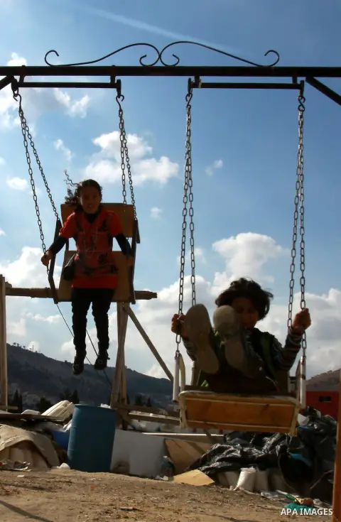 Palestinian children enjoy a ride at an amusement park during the second day of Eid al-Adha in the West Bank city of Nablus, oct 27, 2012. Muslims around the world celebrate Eid-al-Adha, marking the end of the haj, by sl...