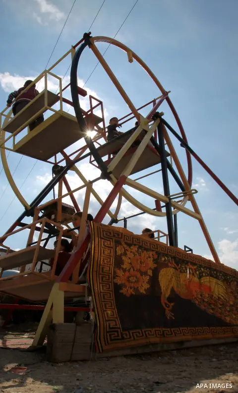 Palestinian children enjoy a ride at an amusement park during the second day of Eid al-Adha in the West Bank city of Nablus, oct 27, 2012. Muslims around the world celebrate Eid-al-Adha, marking the end of the haj, by sl...