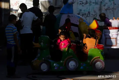 Palestinian children enjoy a ride during the third day of Eid al-Adha in Rafah refugee camp in the southern Gaza Strip on, 28 October 2012. Eid al-Adha, or the Feast of the Sacrifice, is celebrated to commemorate the Pro...